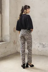 Pantalón de jean corte oxford con estampado de cebra en tonos beige y negro.