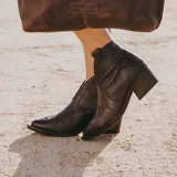 Botines de cuero vacuno color blanco con diseño bordado, taco de madera foliado en cuero de 5cm, cierre del lado interior y horma de punta fina.