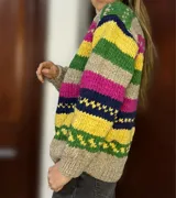 Sweater de lana merino con cuello redondo y diseño con motivos geométricos en tonos azul, marrón, naranja, verde y beige.