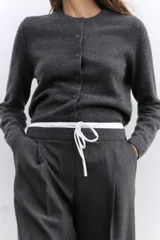 Pantalón ancho gris con textura de espiga, tiro alto, doble cintura elástica ajustable con cordón, pinzas frontales, bolsillos delanteros y falso bolsillo de vivo en la espalda.