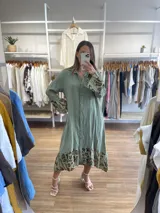 Vestido camisero midi color verde oliva, de lino, con cuello camisero, abotonado al frente, manga larga con puños estampados y ruedo con estampado animal print.