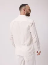 Camisa de manga larga azul, de lino y poliéster, con cuello abotonado y bolsillo en el pecho.