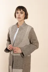 Camisa larga color beige con cuello mao, manga larga con tajo y botón. Diseño con bloques de tela con textura.