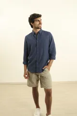 Camisa azul de lino y algodón, de manga larga con cuello abotonado y bolsillo en el pecho.