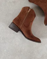 Bota texana marrón de cuero vacuno con caña baja, puntera fina y taco bajo.