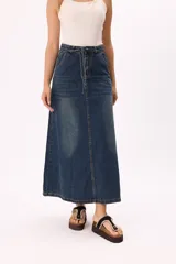 Falda larga de denim azul con lavado vintage, corte evasé, tajo frontal y cintura con lazo ajustable.