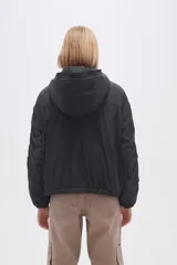 Campera negra de manga larga con capucha, cierre frontal con botones a presión, bolsillos laterales y cordón ajustable en la cintura.