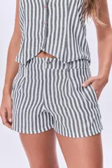 Short de lino a rayas verticales blancas y grises, con bolsillos laterales y cintura alta.