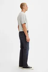 Pantalón de jean de corte slim fit, color azul oscuro, con costuras a la vista en color ocre.