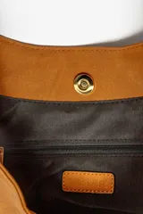 Bolso marrón con forma de media luna y asa de soga trenzada en rojo y blanco.