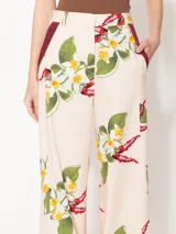 Pantalón wide leg de voile estampado con bordados, cintura con lazo y presillas, abertura en el lateral inferior y complemento bordó en la boca del bolsillo.