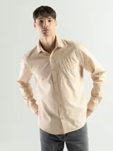 Camisa de manga larga color verde oliva, confeccionada en algodón. Tiene corte clásico, bolsillo en el lado izquierdo del pecho y cierre con botones.