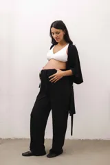 Conjunto de ropa de descanso para maternidad compuesto por un pantalón negro de tiro alto y corte ancho con cordón ajustable, un top de lactancia blanco con escote en V y una bata negra de manga ancha con lazo para atar.