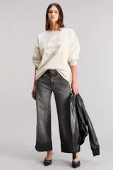 Buzo color crema de calce oversize, confeccionado en tejido premium con algodón. Tiene cuello, cintura y puños en ribb. Posee estampa con diseño exclusivo de la colección en delantero y hotfix.