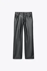 Pantalón negro de tiro medio, con trabillas en la cintura, cinco bolsillos y pernera ancha. Cierre frontal con cremallera, botón oculto y gancho metálico.