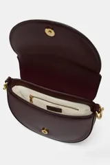 Bolso de hombro ovalado color negro, con asa de doble tira redonda con detalles metalizados dorados. Cierre imantado y asa de bandolera extraíble con tejido a contraste. Bolso interior con cierre mediante cremallera metálica.