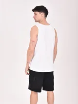 Musculosa blanca de algodón con estampado de un esqueleto surfeando en la playa.