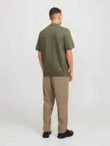 Polo de punto color verde oliva con cierre de cremallera, cuello polo y mangas cortas.