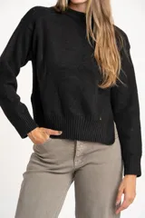 Sweater de punto color negro confeccionado en mezcla de lana lambswool y nylon. Presenta cuello alto tipo polera, manga larga y terminaciones acanaladas en puños y bajo.