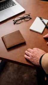 Billetera de cuero color marrón claro con volante interior, dos visores, tarjeteros y bolsillos. Cuenta con doble repartición para billetes y una repartición con cierre en la parte posterior interna.