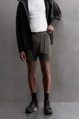 Shorts de running negros confeccionados en tejido técnico ligero y elástico, con malla interior, cintura elástica ajustable con cordón, bolsillo trasero con cierre y perforaciones en las perneras.
