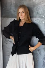 Chaqueta con estampado animal print en tonos marrones, con cuello camisero, cierre frontal con botones negros y detalle de volantes en el frente.