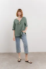 Blusa celeste de lino, con escote en V, manga tres cuartos y botón de madera.