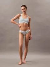 Conjunto de ropa interior Calvin Klein, compuesto por un bralette deportivo sin relleno y una bombacha tipo bikini, ambos en color celeste con banda elástica blanca con el logo de la marca.