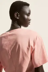 Remera de manga corta color rosado, de punto suave de algodón, con escote bote y hombros caídos.