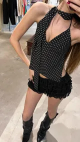Top halter negro con lunares blancos, de tela tipo gasa, para atar al cuello y con espalda descubierta. Incluye corbatín.