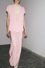 Top de punto color rosa, de cuello redondo y manga corta ancha.