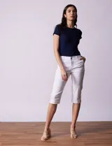 Pantalón capri blanco de algodón elastizado. Pretina con pasadores, botón y cierre. Delantera con bolsillos. Trasera con bolsillos simulados.