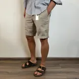 Bermuda gris oscuro de gabardina, con bolsillos laterales y traseros.