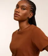 Blusa básica de algodón color tostado, de manga corta con dobladillo y nudo frontal.