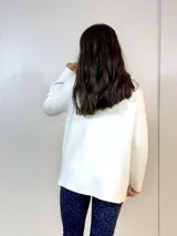 Sweater blanco de cuello alto con abertura frontal.