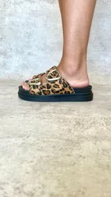 Sandalias con estampado animal print, dos tiras con hebillas plateadas y plataforma baja.