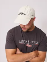 Gorra de gabardina color crudo con visera curva y logo de la marca bordado en negro en el frente.