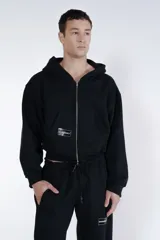 Campera negra con cierre frontal, capucha y logo de la marca en el pecho.