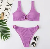 Conjunto de bikini lila texturizado, con corpiño con aro de madera en el centro y bombacha con aros de madera en los laterales.