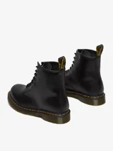 Bota negra de 8 ojales, con costura amarilla y suela con amortiguación de aire, hecha de cuero duradero.