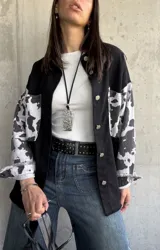 Sobrecamisa negra con mangas estampadas con diseño de vaca.