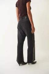 Pantalón de jean de corte ancho con estampado de piel de cocodrilo color bordó.