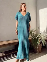 Vestido largo de tejido de punto calado color beige, con escote en V y mangas cortas.