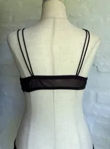 Body negro con breteles finos, escote en V y transparencias en el abdomen.