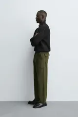 Jersey de punto perlado negro, de corte relaxed fit, con cuello perkins y cierre frontal de cremallera.