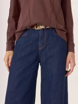 Pantalón ancho de algodón color verde militar, con corte holgado, pinzas debajo de la rodilla y pespuntes a contratono. Presenta un bordado de monograma en el bolsillo delantero.