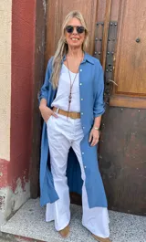 Sobrecamisa larga azul de viscosa con cuello camisero, manga larga con puños abotonados y tajos laterales.