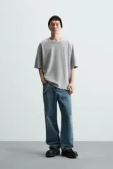 Camiseta azul marino de corte holgado, confeccionada en algodón con cuello redondo y mangas cortas. Presenta un efecto de lavado que le da una apariencia única.
