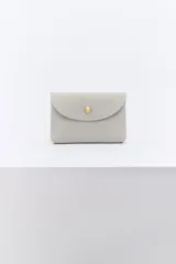 Monedero pequeño de cuero texturizado color azul con cierre de broche metálico dorado.