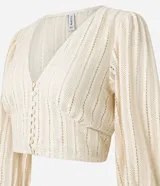 Blusa corta de encaje guipir de algodón con escote en V, botones frontales y manga larga abullonada con puño elástico.